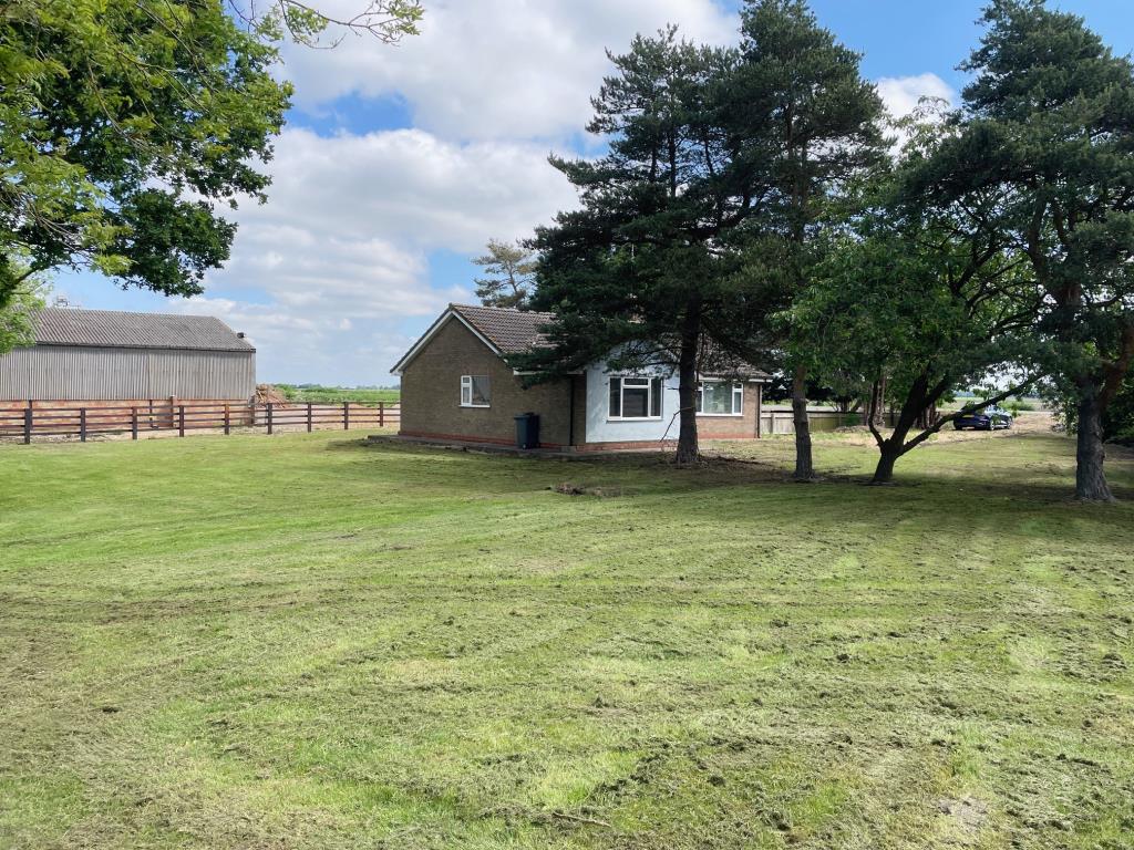 Lot: 76 - A DETACHED BUNGALOW FOR IMPROVEMENT AND REPAIR - View of the bungalow from the rear showing gardens